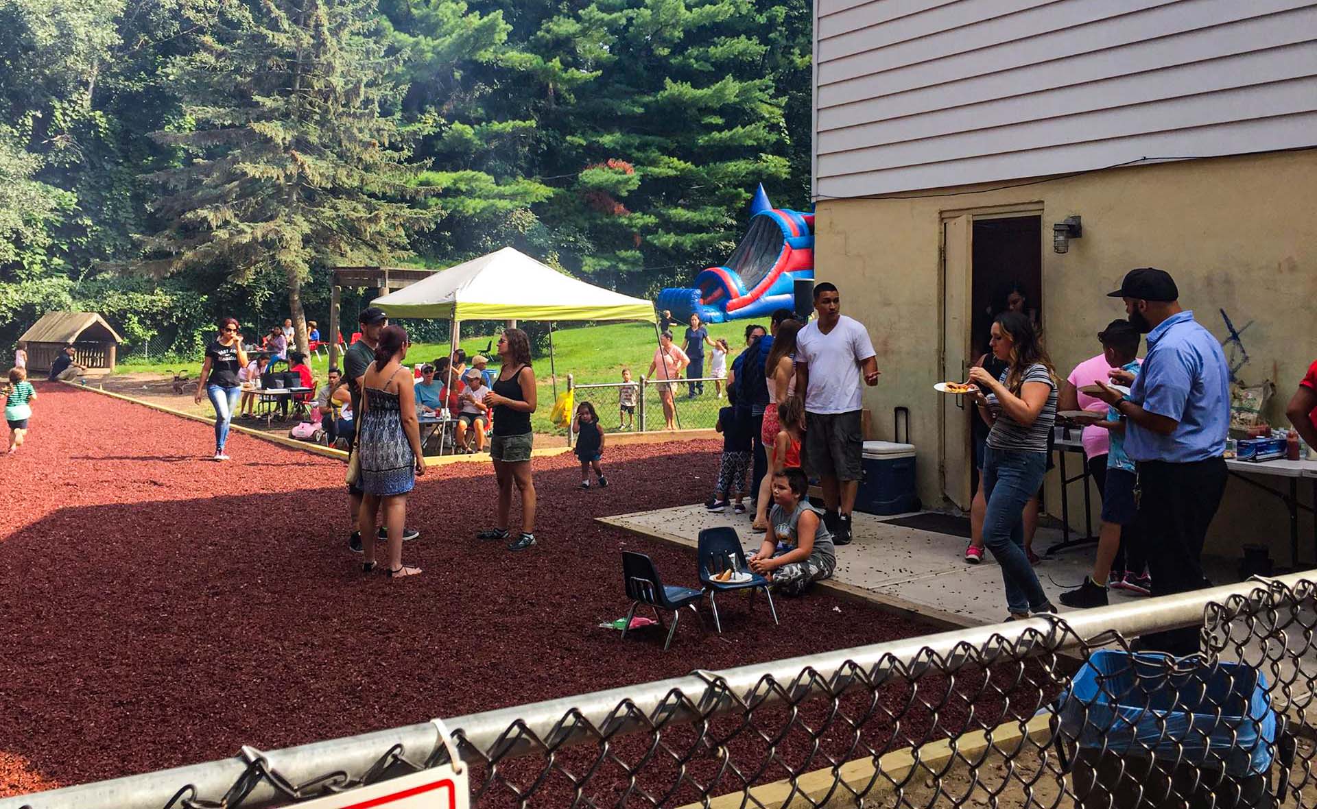 Families Picnic in the yard with Bounce House and Tent