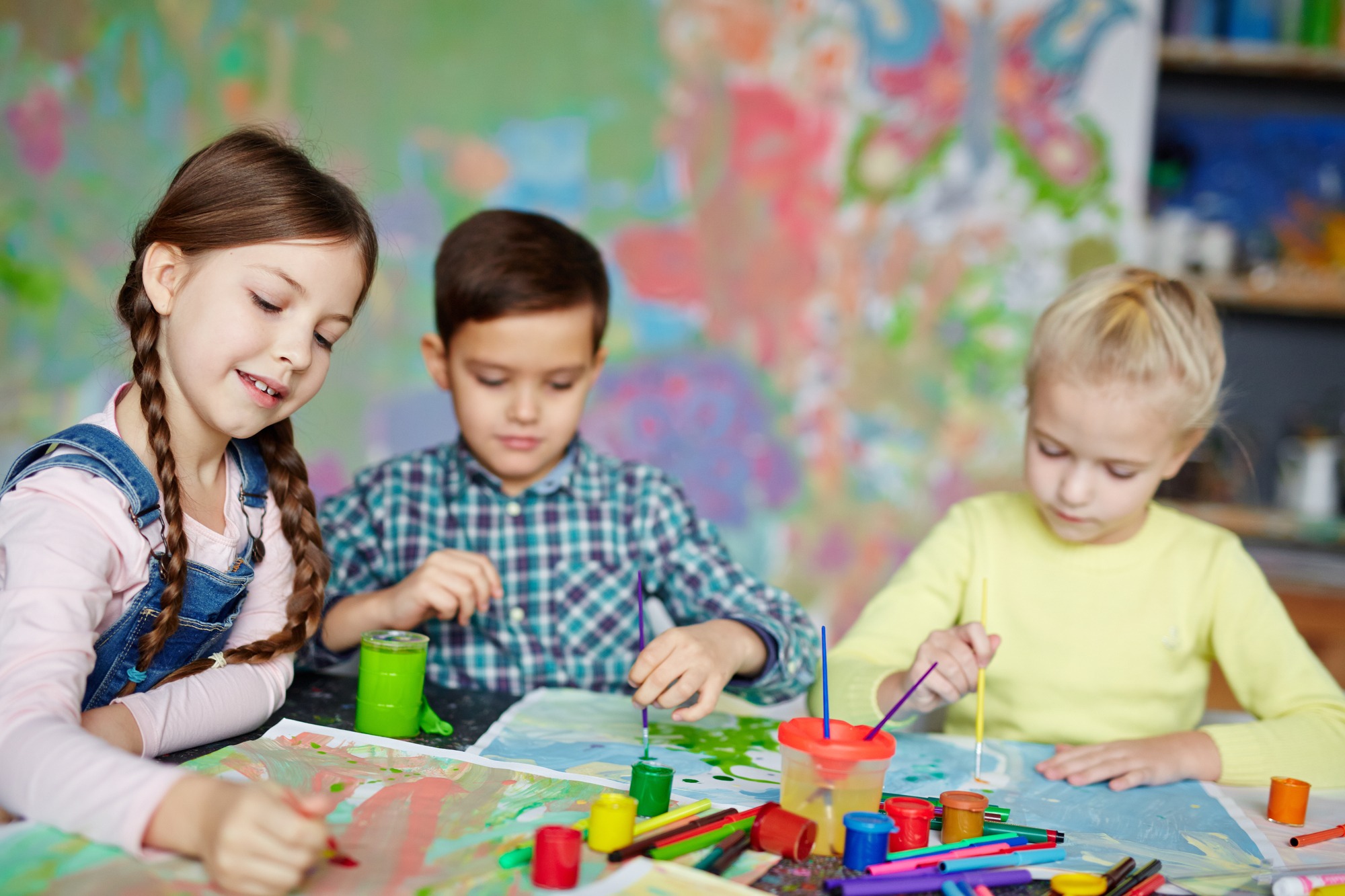 Group of cute kids painting with gouache